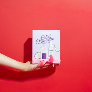 Fond rouge avec une main qui tient le coffret vu de face
